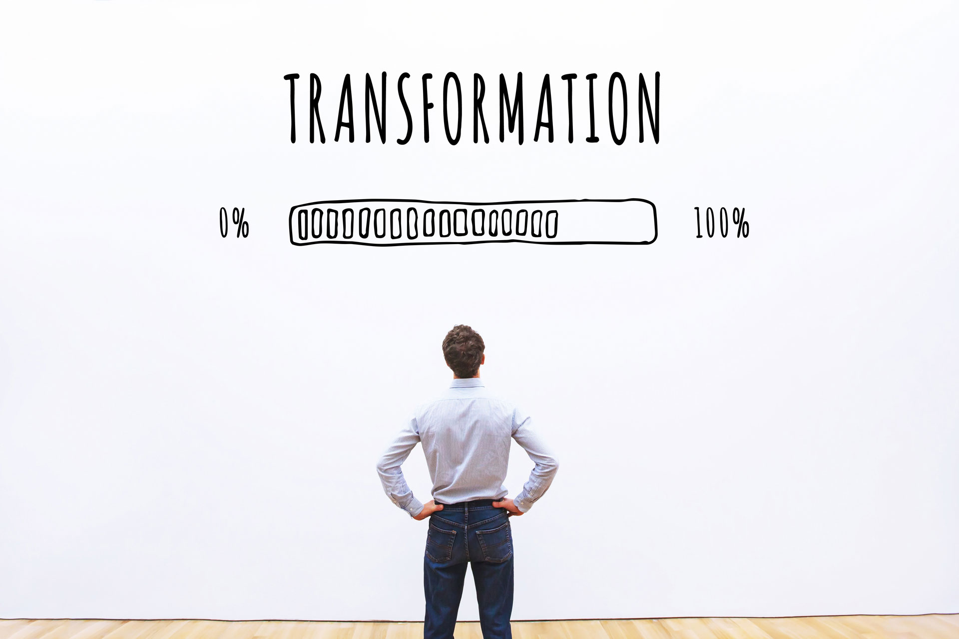 Ein Mann steht vor einer Wand, auf der Transformation geschrieben steht.