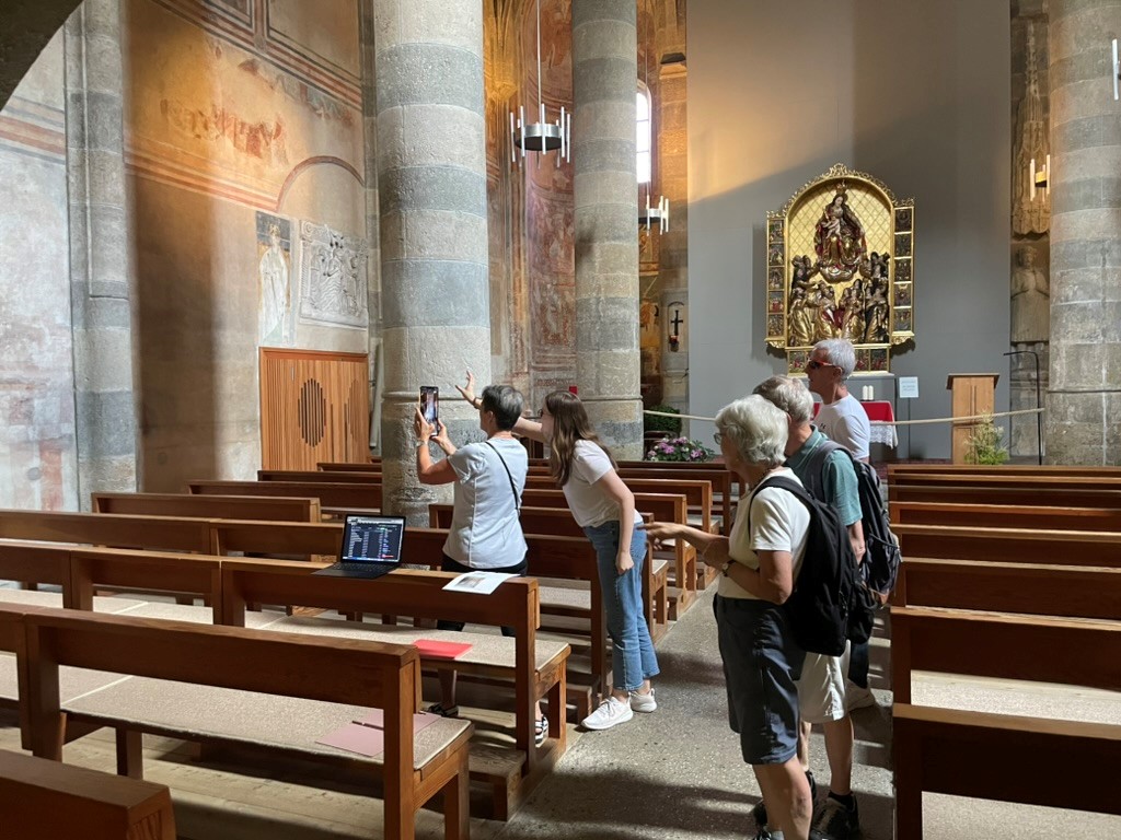 Besucher in der Klosterkirche probieren die App aus, Sarah Büttler erklärt ihnen die Funktionsweise